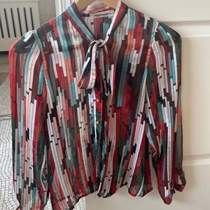 Sheer colored shirt with a tie bow and gold buttons